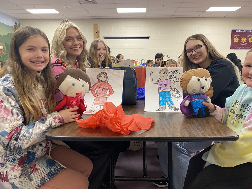 Students with drawings and dolls