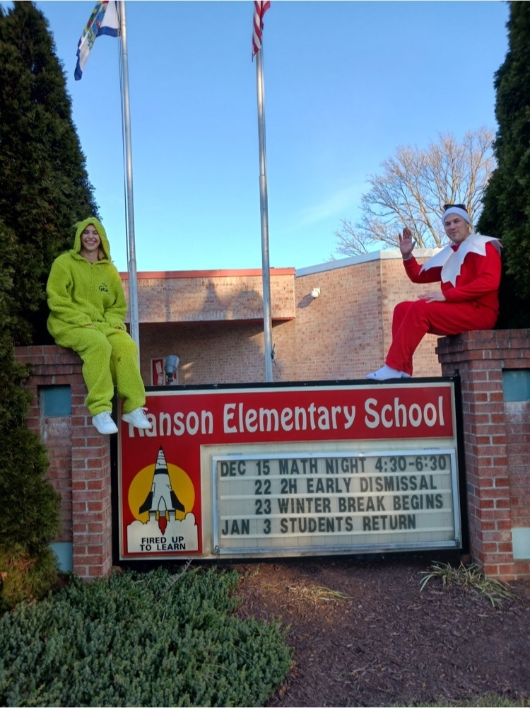 administration dressed up as elf and Grinch in front of the school 