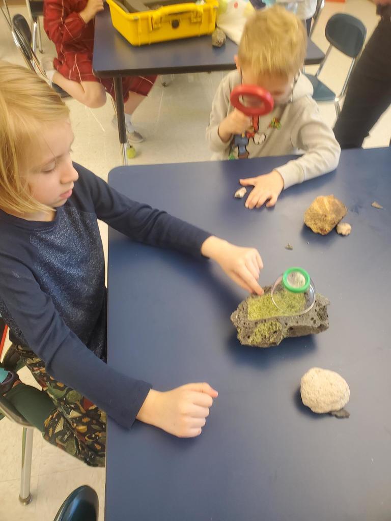 student looking at a rock
