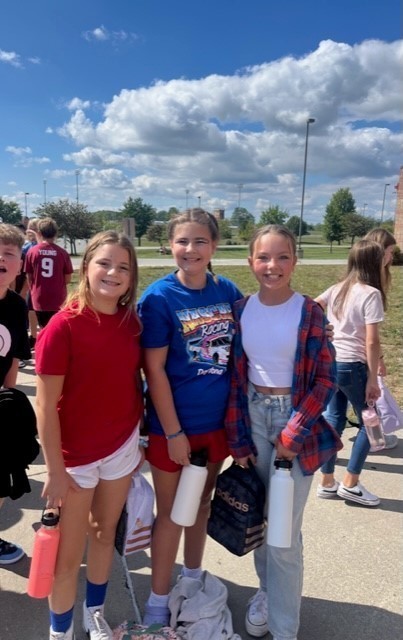 Three female students dressed in red, white and blue