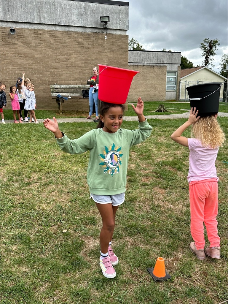 Two students in a race with buckets on their heads