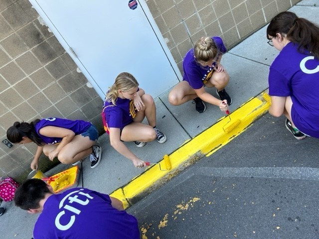 students painting a curb